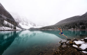 Man jumping into freezing mountain lake.