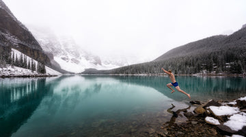 Man jumping into freezing mountain lake.