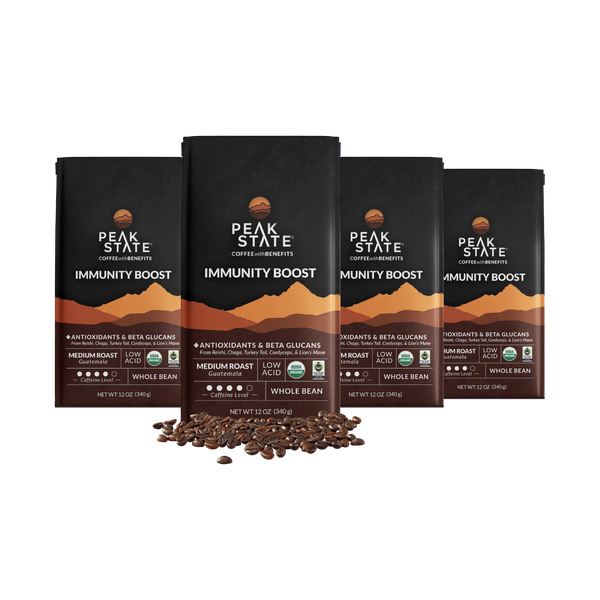 4 x 12oz bags of Peak State's Immunity Boost whole bean coffee surrounded by coffee beans.