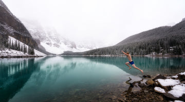 Man jumping into freezing mountain lake. 