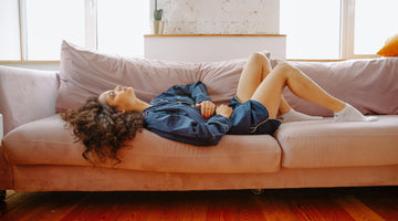 Woman lying on the sofa with heartburn.