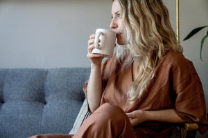 Woman sipping coffee on the couch.