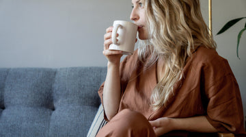 Woman sipping coffee on the couch.