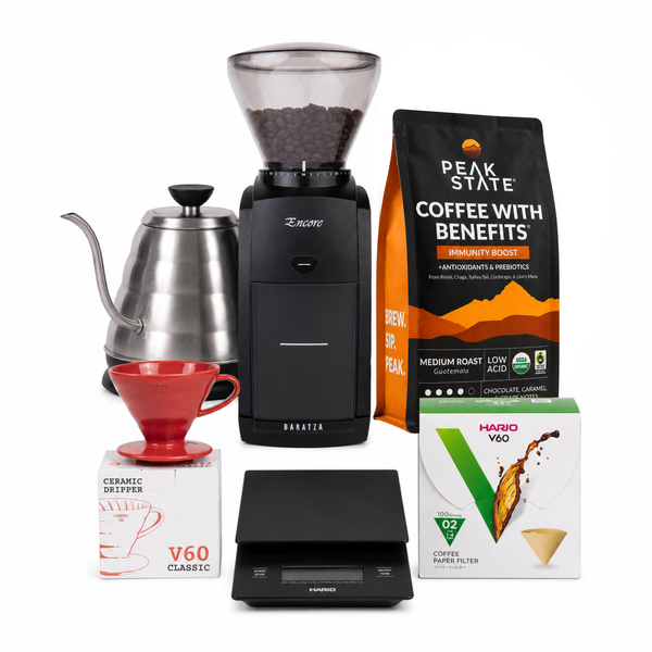A coffee brewing kit featuring a Brémner grinder, a stainless steel gokuroh kettle, a red ceramic pour-over dripper, a digital scale, a box of Peak State Coffee with Benefits, and a box of Maruk V60 coffee paper filters, all arranged on a white background.