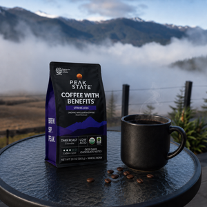 Peak State Stress Less coffee on a table overlooking a foggy mountain view
